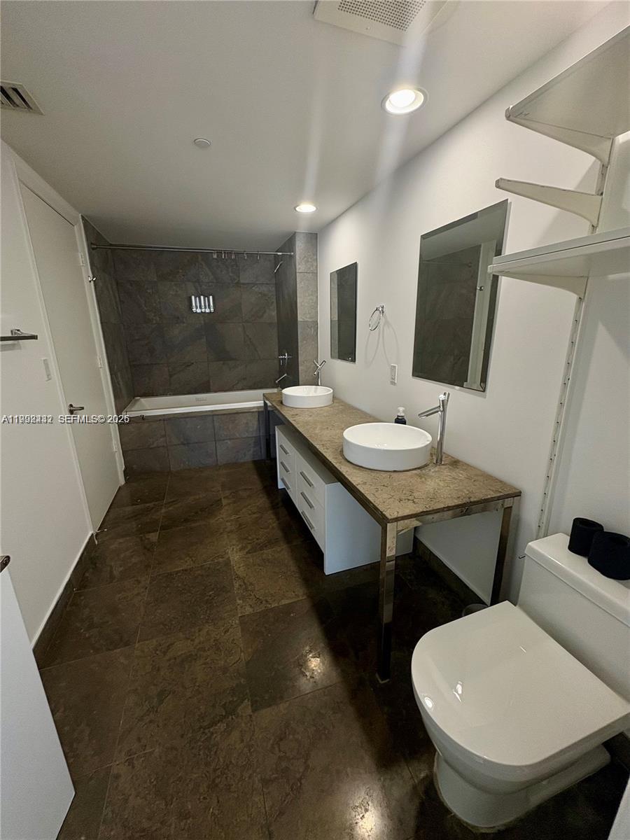 495 Brickell Avenue, Unit 3909 Miami, FL 33131 - Photo 11 of 11 a room with furniture a flat screen tv and a toilet