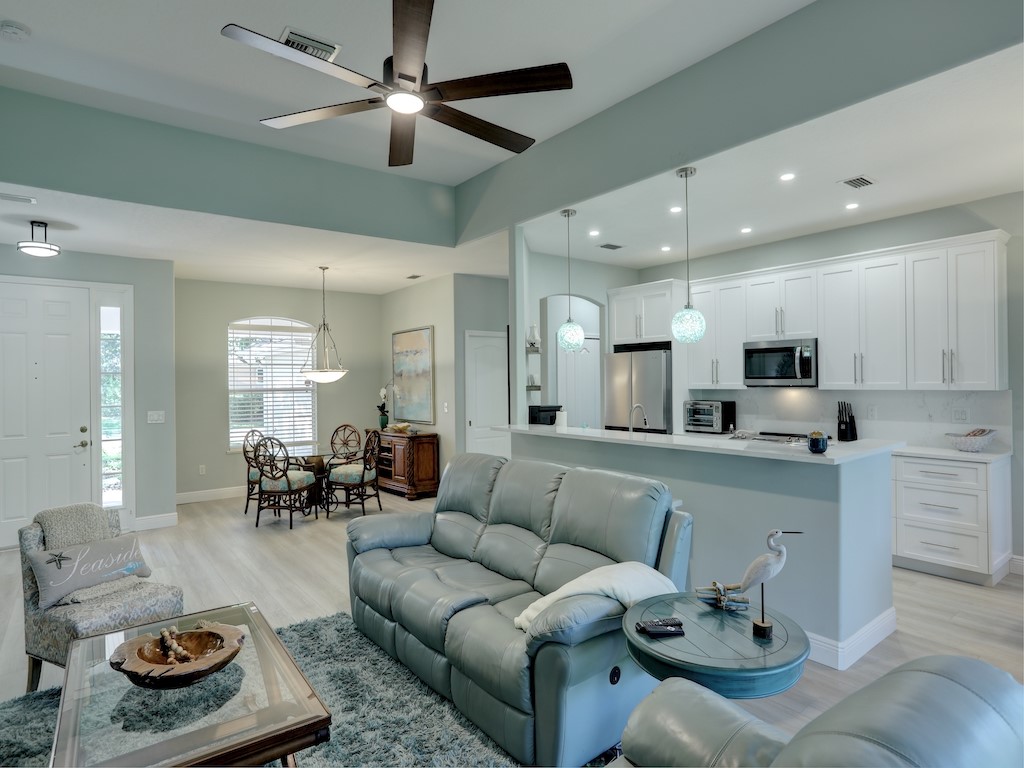 a living room with furniture kitchen view and a chandelier