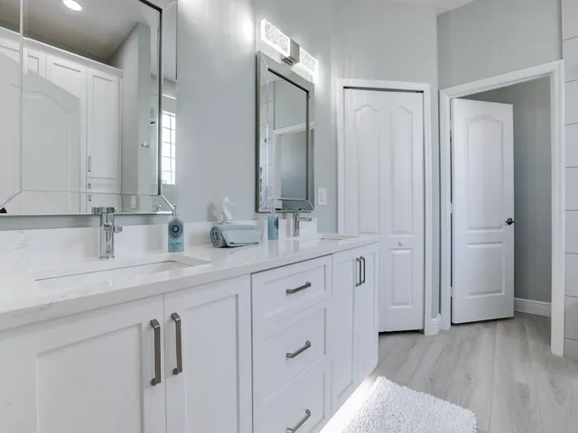 a en suite bathroom with a sink double vanity and a mirror