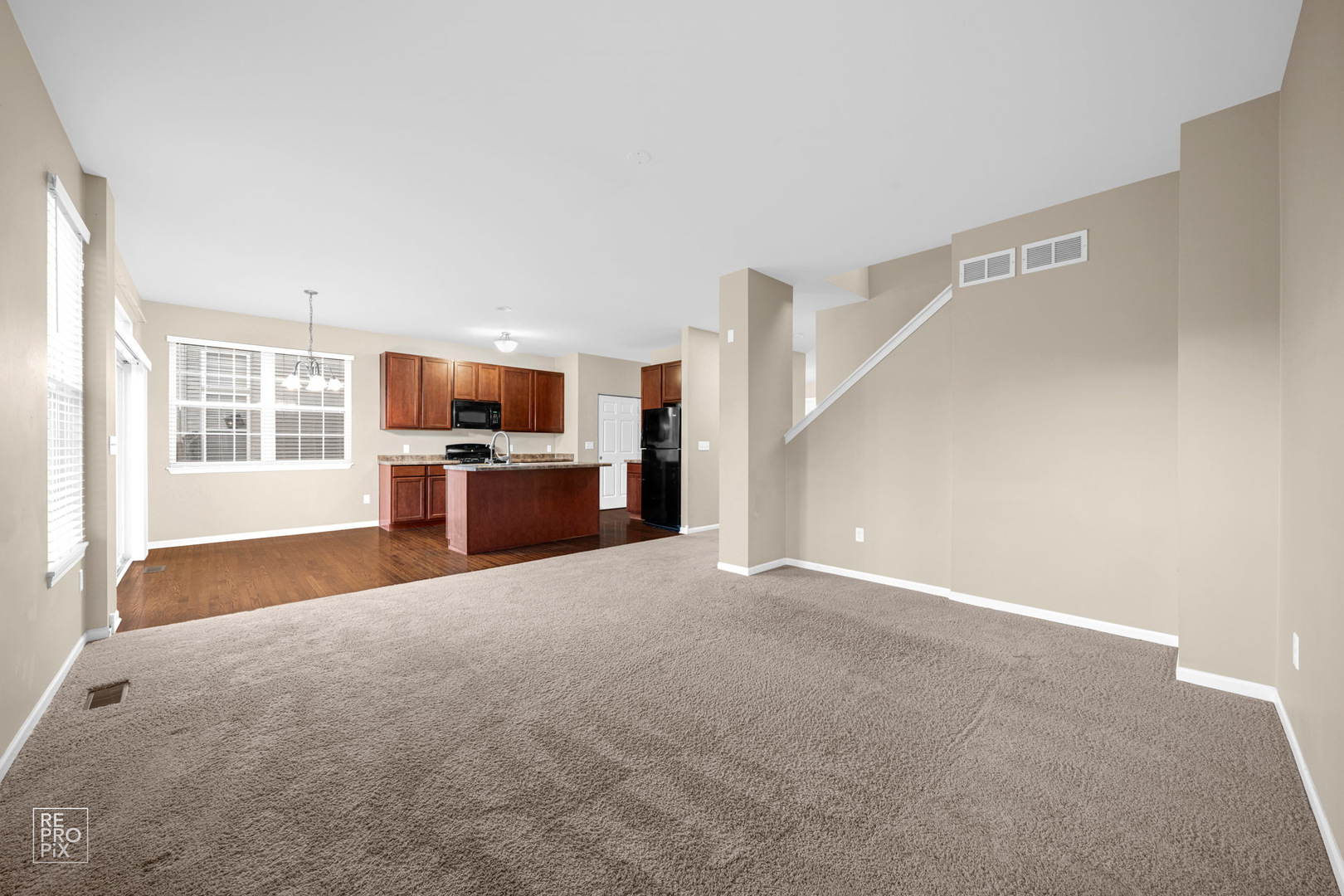 2218 Surrey Street Sycamore, IL 60178 - Photo 6 of 18 a view of empty room with a kitchen and fireplace