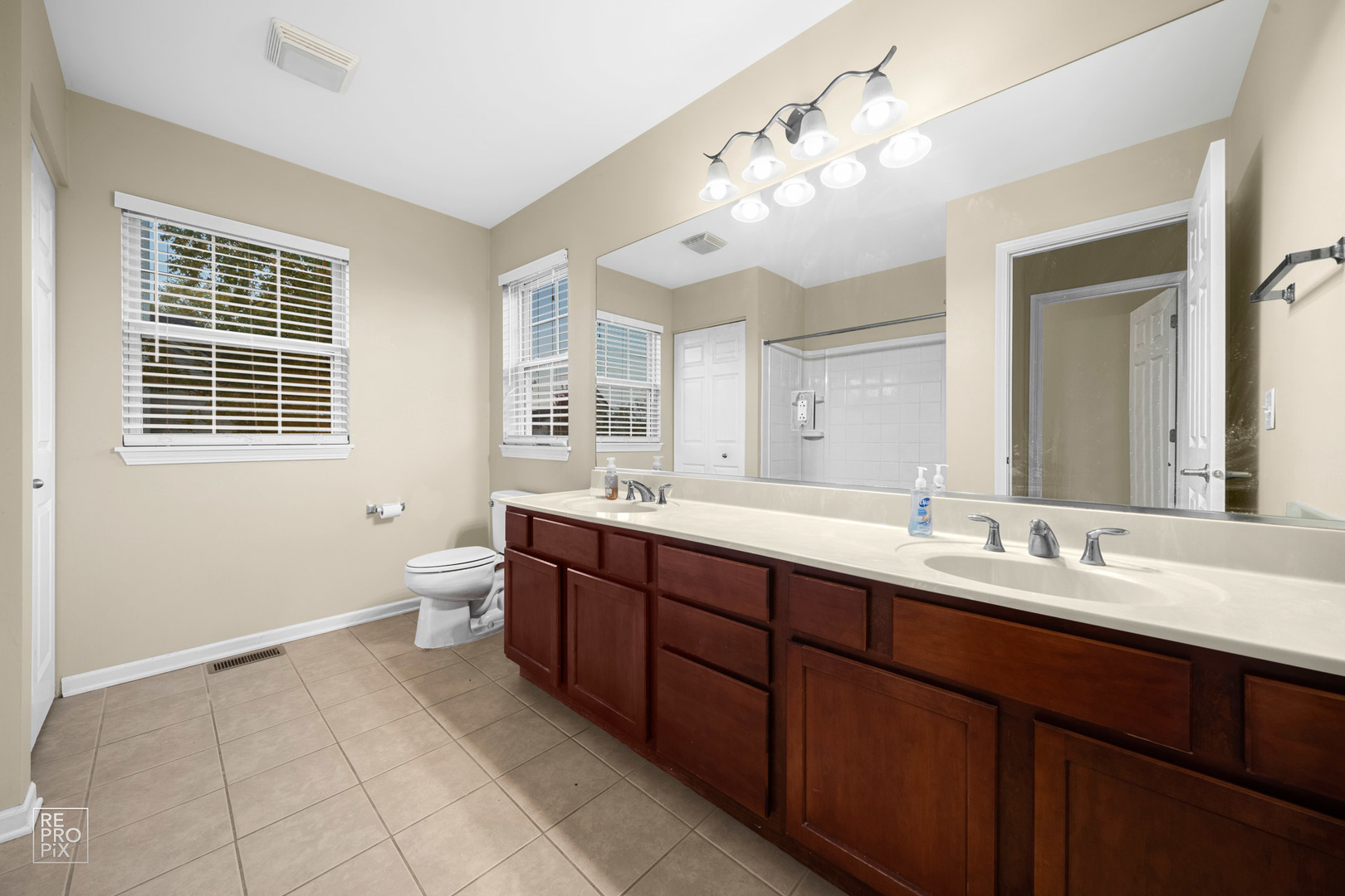 2218 Surrey Street Sycamore, IL 60178 - Photo 9 of 18 a spacious bathroom with a double vanity sink a large mirror and a bathtub