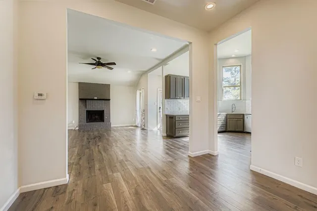 a view of empty room with a fireplace and wooden floor