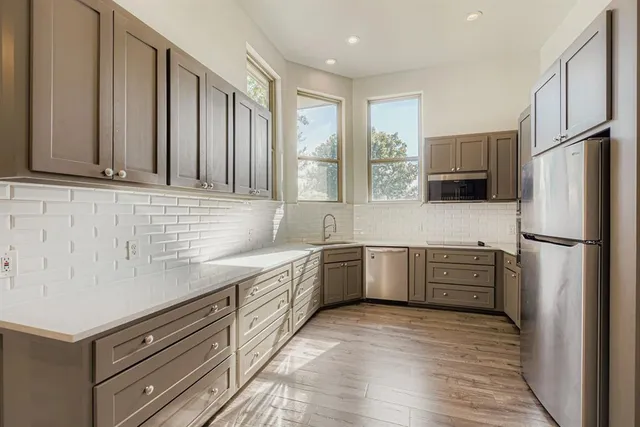 a kitchen with a refrigerator stove top oven and sink