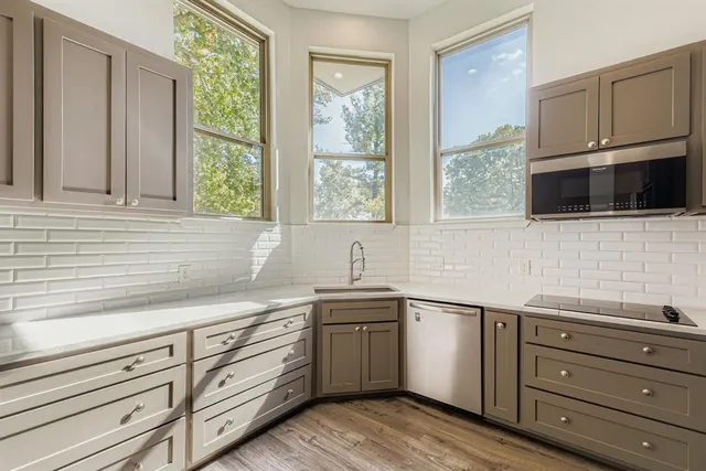 a kitchen with granite countertop white cabinets and a window