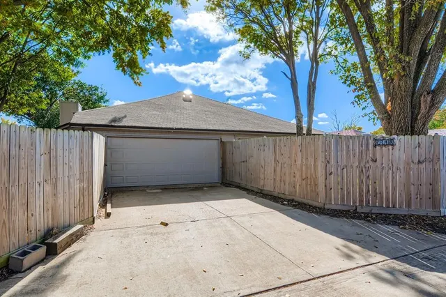 a view of backyard with wooden fence and a large tree
