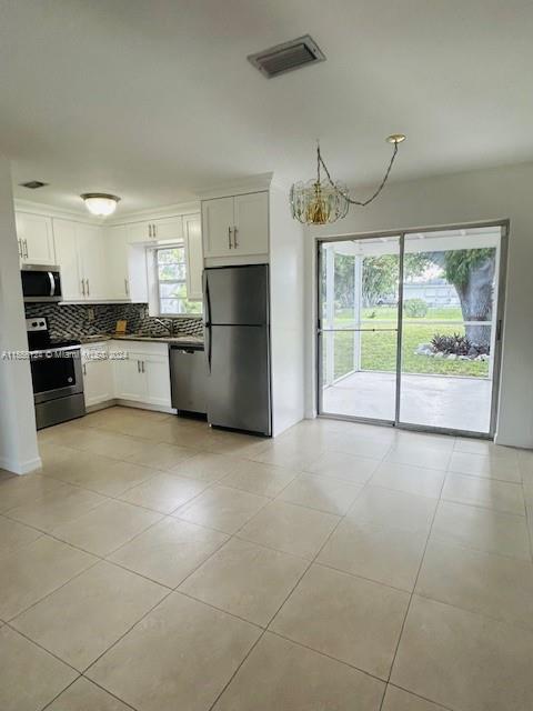 225 Davis Road Palm Springs, FL 33461 - Photo 5 of 19 a kitchen with a refrigerator a stove top oven a sink and a large window