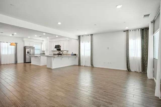 a view of a kitchen with a refrigerator and a stove top oven