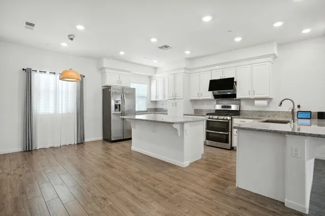 a kitchen with stainless steel appliances a refrigerator and a stove top oven