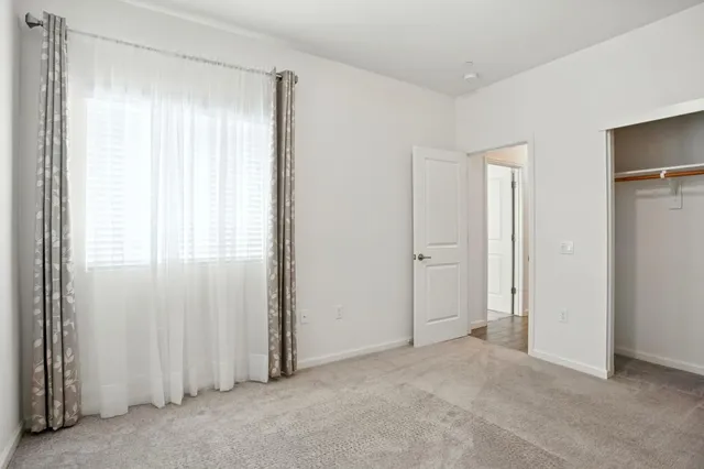an empty room with windows and closet
