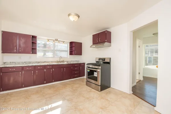 a view of a room with wooden floor and a window