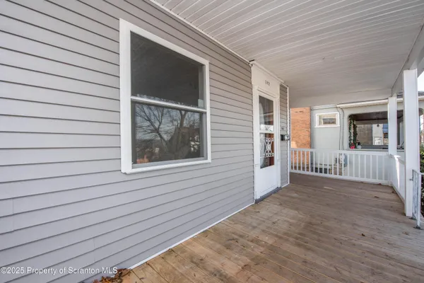 a view of a porch with wooden floor and a yard