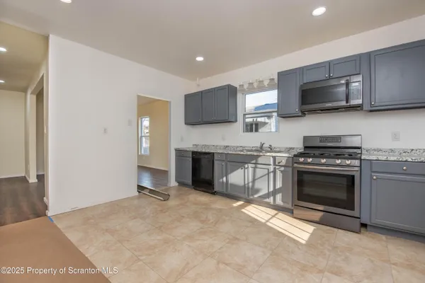 a kitchen with stainless steel appliances granite countertop a stove and a sink