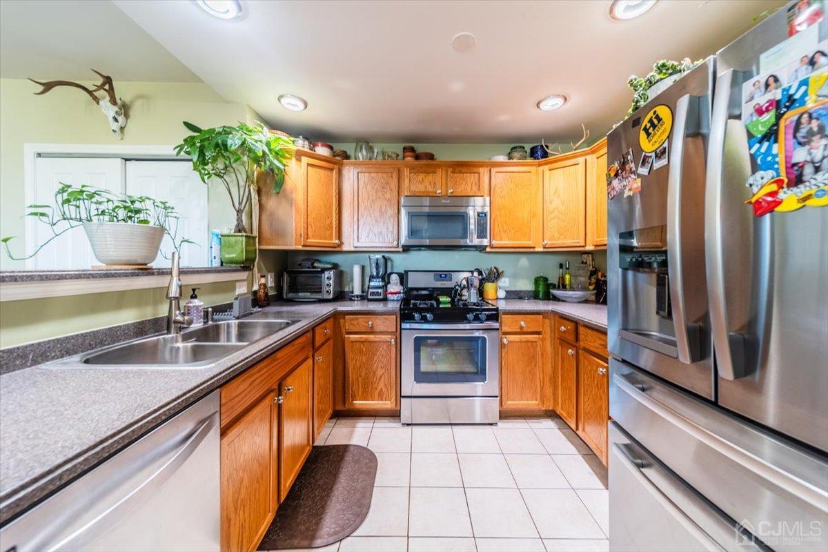 358 Rector Street, Unit 509 Perth Amboy, NJ 08861 - Photo 8 of 26 a kitchen with stainless steel appliances granite countertop a sink a counter space and a window