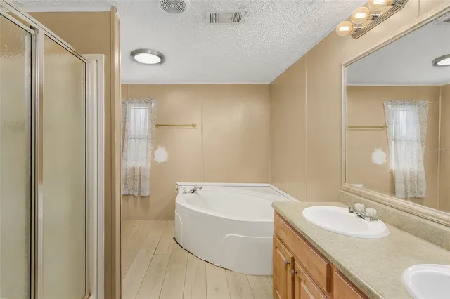 a bathroom with a tub a sink and mirror
