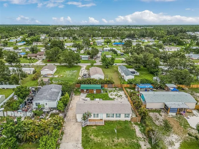 an aerial view of a house with a yard and lake view