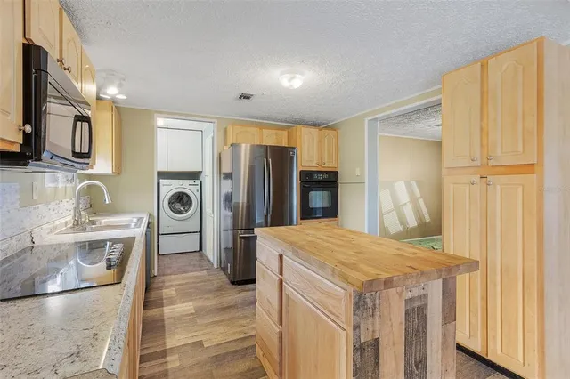 a kitchen that has a refrigerator a stove and wooden cabinets