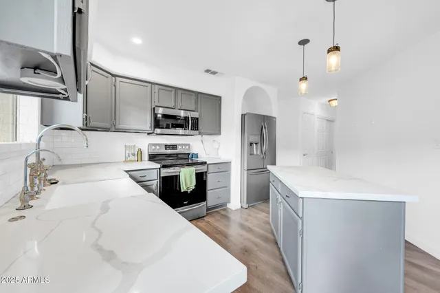 a kitchen with a sink cabinets and wooden floor
