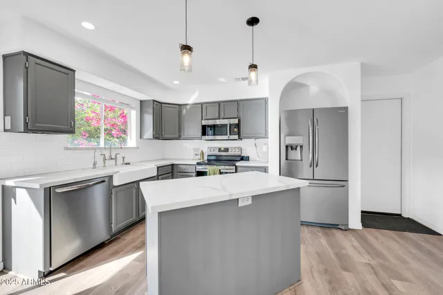 a kitchen with kitchen island a sink stainless steel appliances and window