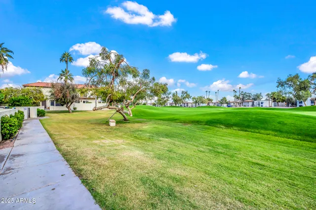 a view of a swimming pool with a lawn chairs under an umbrella
