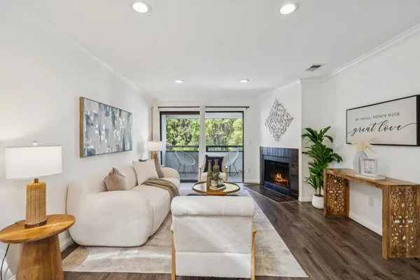 a living room with furniture a fireplace and a potted plant