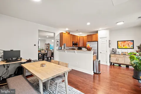 a kitchen with a table chairs refrigerator and cabinets