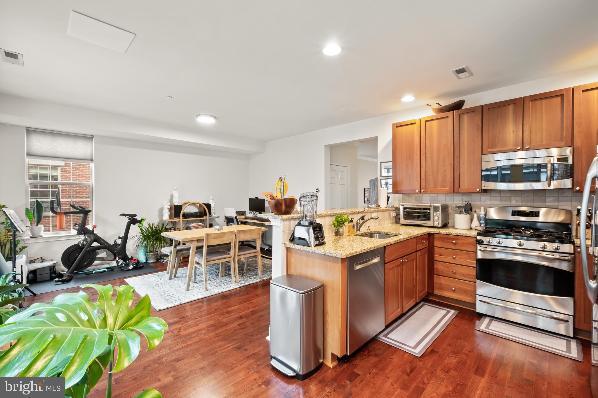 112 Commodore Court Philadelphia, PA 19146 - Photo 14 of 55 a kitchen with stainless steel appliances granite countertop a stove top oven a sink dishwasher a dining table and chairs with wooden floor