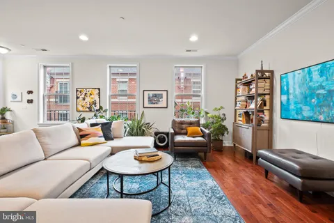 a living room with furniture a rug and a window