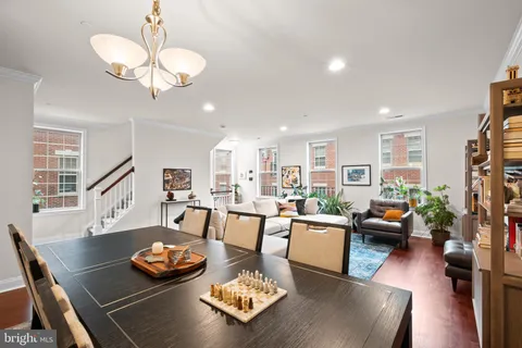 a living room with furniture kitchen view and a wooden floor