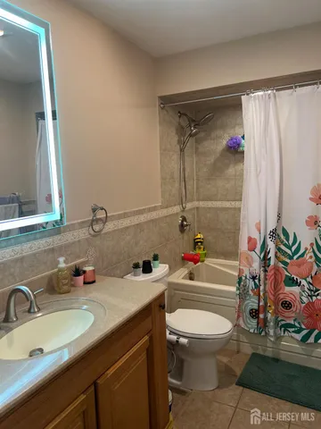 a bathroom with a granite countertop sink mirror vanity and toilet