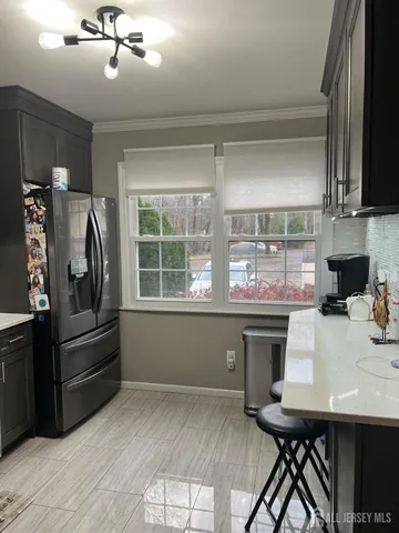 a kitchen with a table chairs refrigerator and cabinets