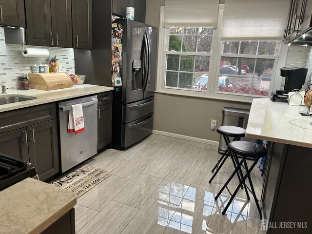 a kitchen with stainless steel appliances kitchen island a table chairs in it and wooden floors