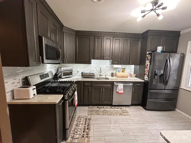 a kitchen with stainless steel appliances granite countertop a sink stove and refrigerator