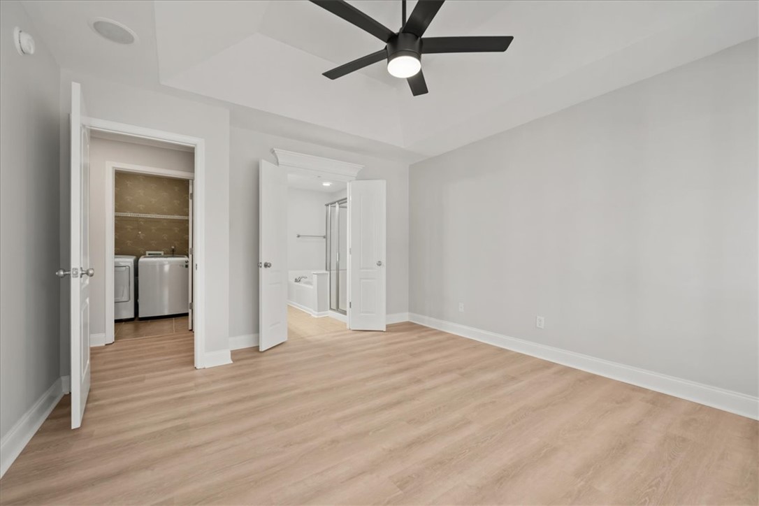 100 Shipyard Circle Anderson, SC 29621 - Photo 20 of 40 This primary bedroom features light wood flooring, a ceiling fan, and convenient access to a private bathroom and laundry.