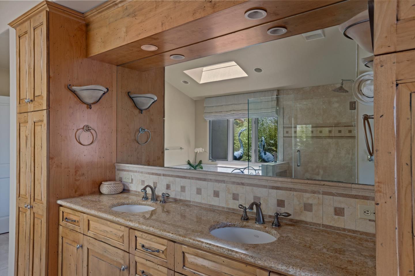 11502 Saddle Road Monterey, CA 93940 - Photo 17 of 40 a bathroom with a granite countertop sink a mirror and shower