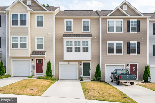 a front view of a house with cars parked