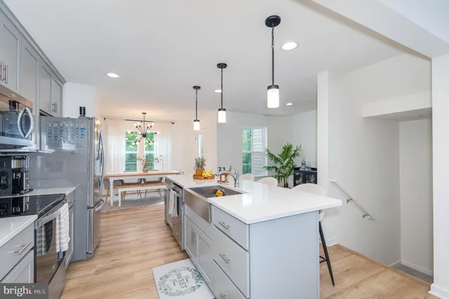 a kitchen with a sink stove and wooden floor