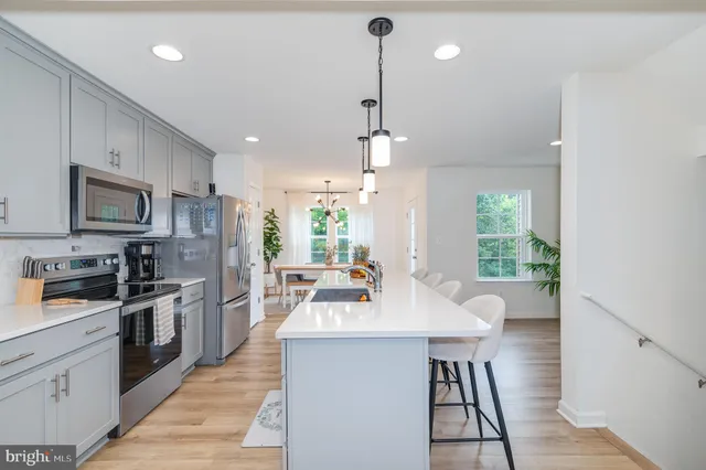 a kitchen with a sink a counter top space stainless steel appliances and a window