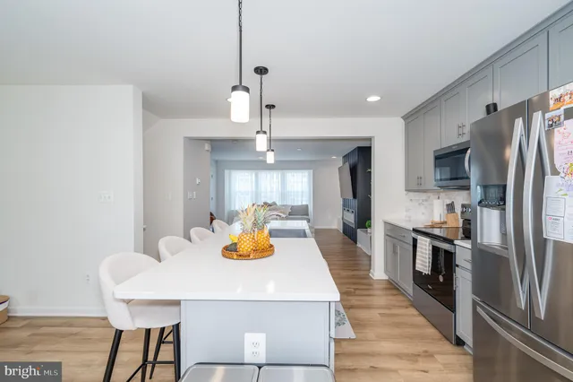 a kitchen with a chandelier a sink and refrigerator