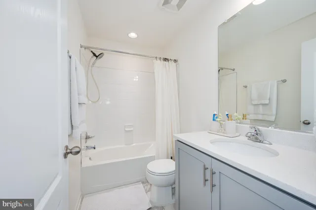 a spacious bedroom with a bed and a dresser