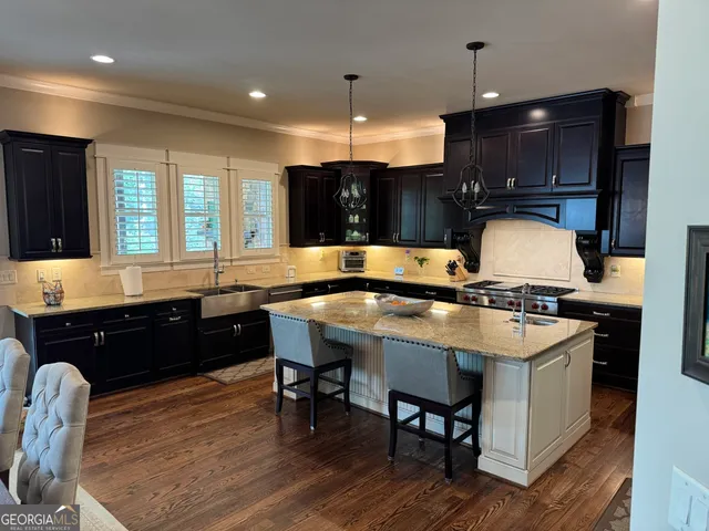 a kitchen with a stove a sink dishwasher a dining table and chairs with wooden floor