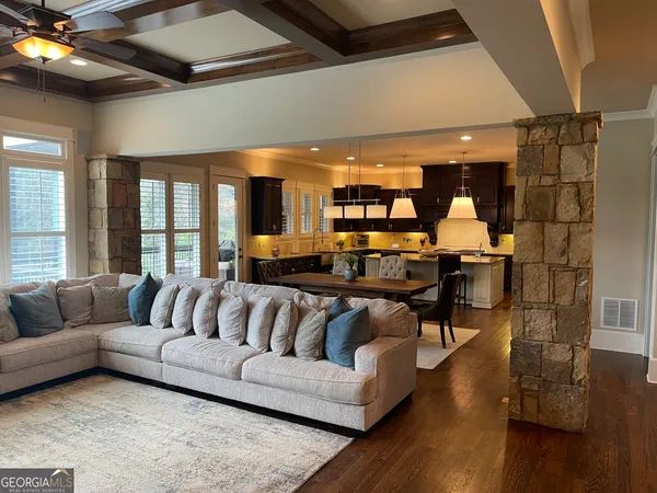 a kitchen with a stove a sink dishwasher a dining table and chairs with wooden floor