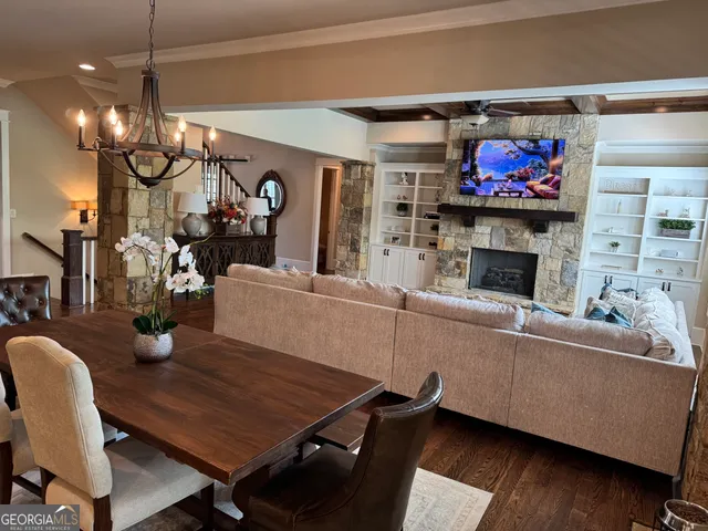 a living room with furniture a flat screen tv and kitchen view