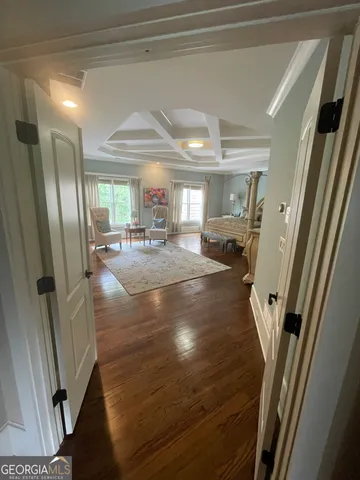 a view of a hallway with furniture and a chandelier