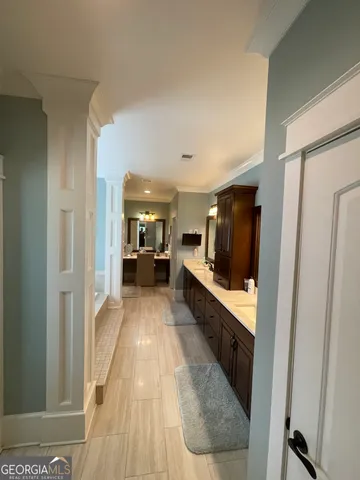 a view of a living room with a sink and wooden floor