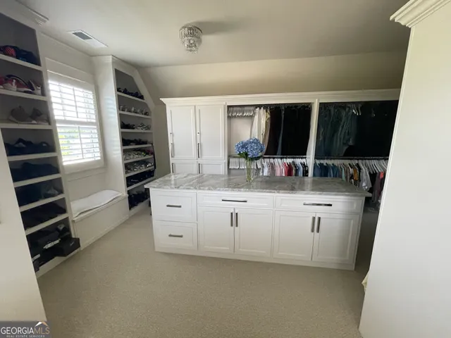 a kitchen with white cabinets and window
