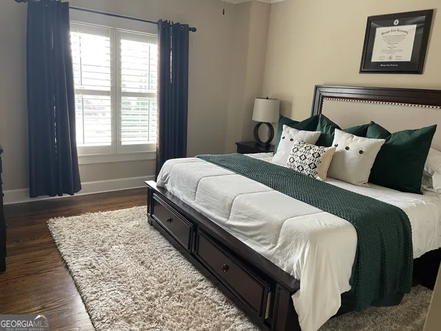 a large bed sitting in a bedroom next to a window