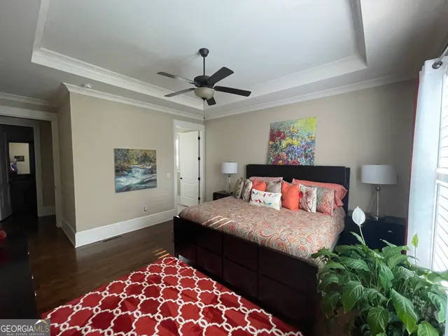 a bedroom with a bed and a lamp on the dresser