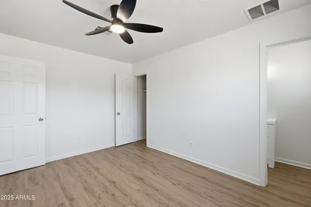 a view of empty room with wooden floor