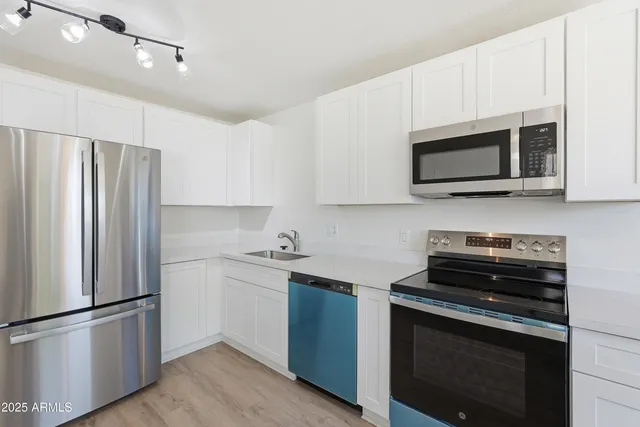 a kitchen with a sink and steel appliances