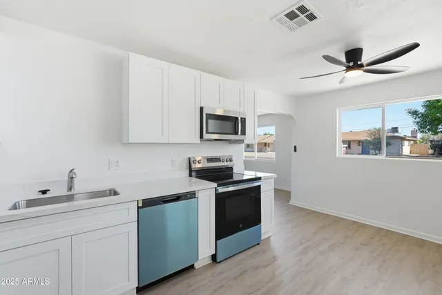 a view of a refrigerator in kitchen and white cabinets